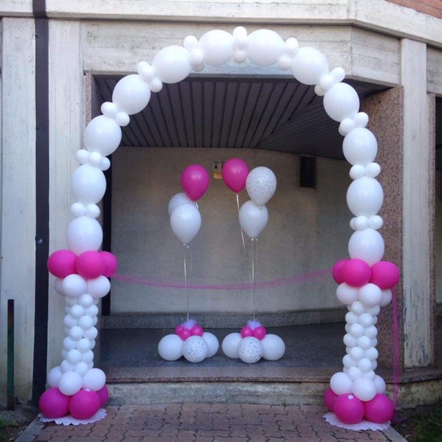 Arco di palloncini e totem bianchi e rosa